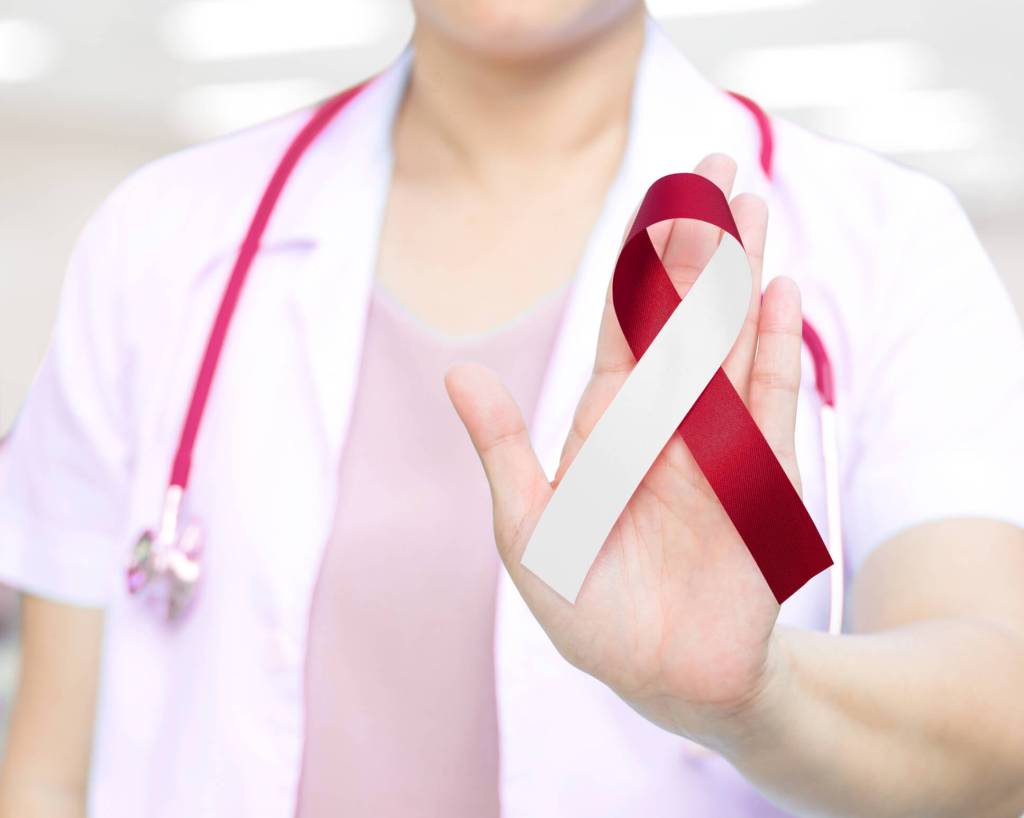 Doctor holding up red and white cancer awareness ribbon