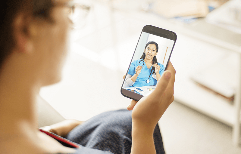 Over shoulder view of woman talking to doctor on phone