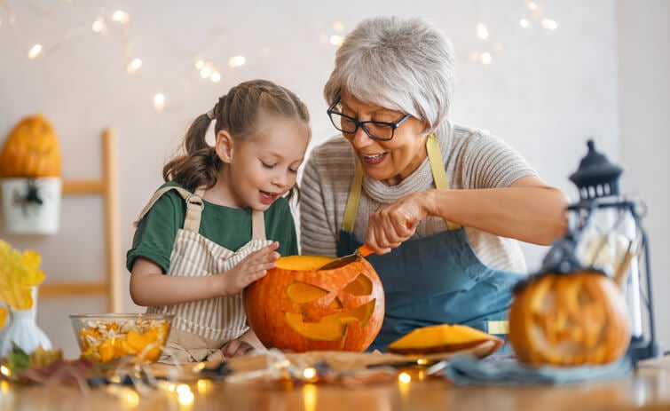 A mother and daughter carving a pumpkin