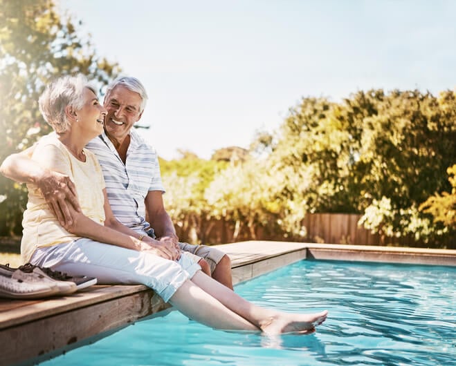 An older couple relaxing by a pool
