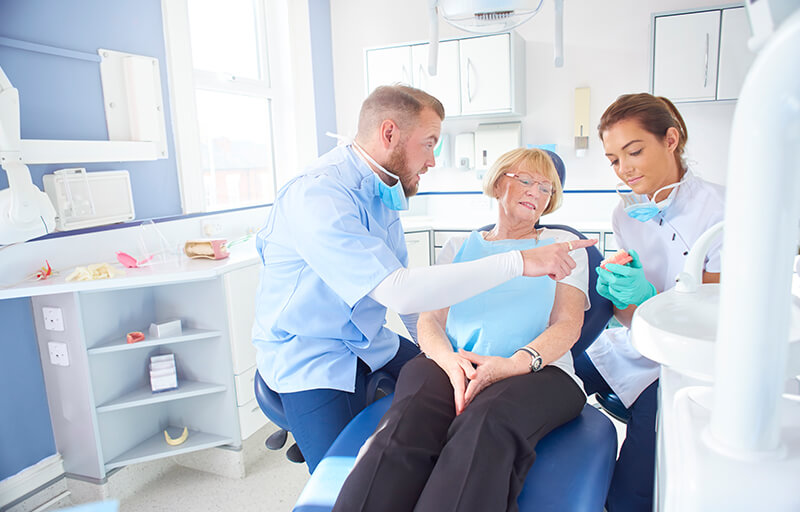 A dentist explaining something to a patient