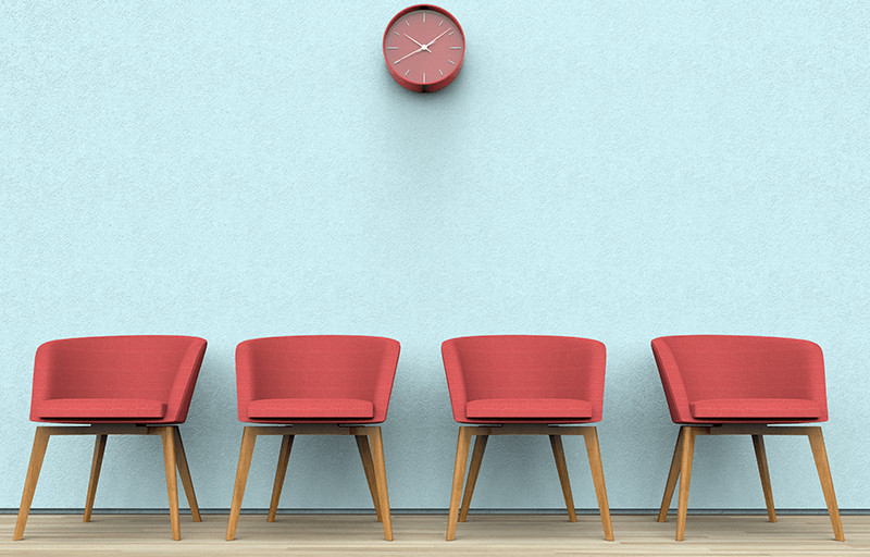 A clock above four chairs