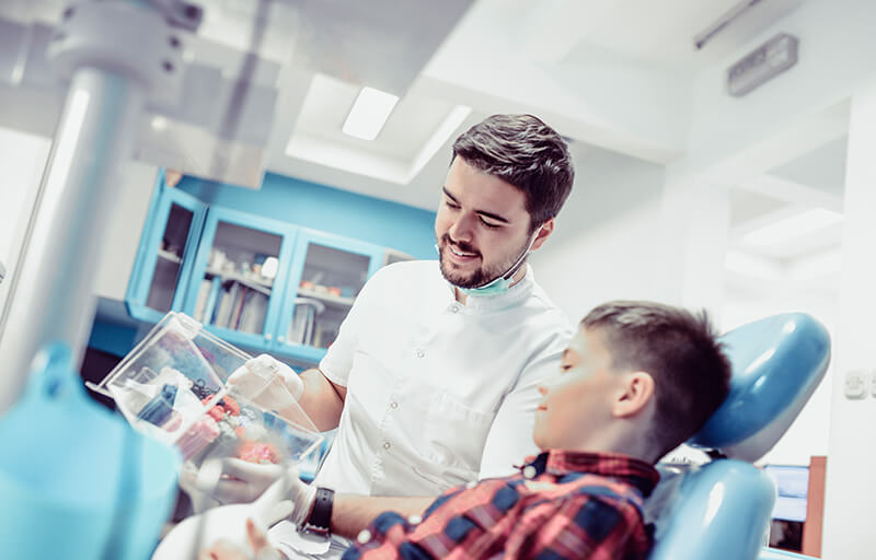 A dentist showing a young patient dental options
