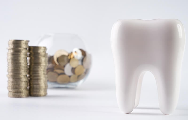 A large model tooth and a jar of coins