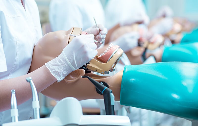 A dentist practicing on a dummy
