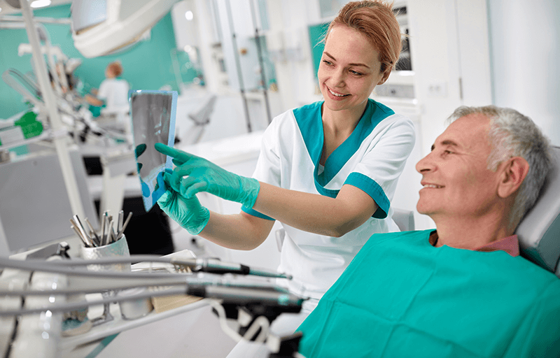 A dentist shows a patient his x-rays