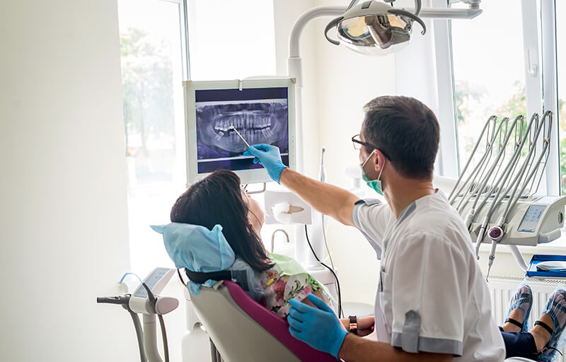 Periodontist reviewing and x-ray with a patient