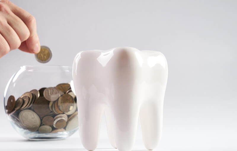 A jar of coins and porcelain tooth statuesque