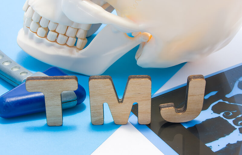 Skull and doctor tools behind wooden TMJ letters