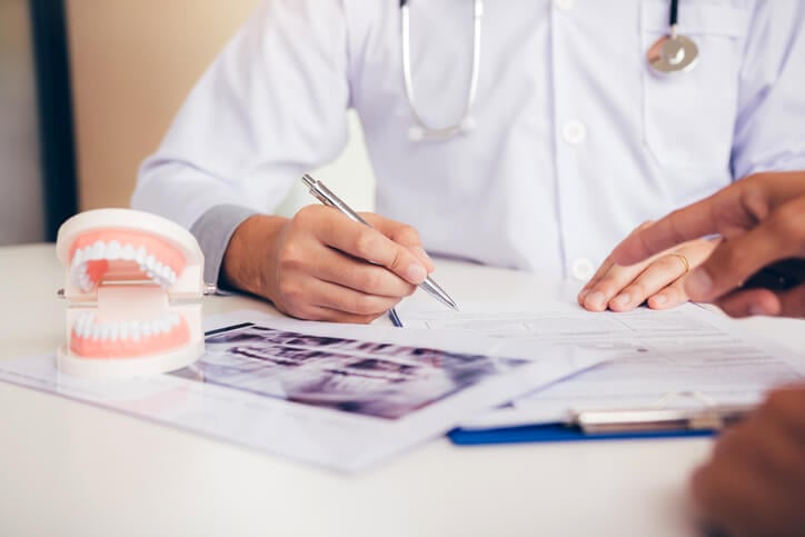 A dentist taking notes next to a set of chompers