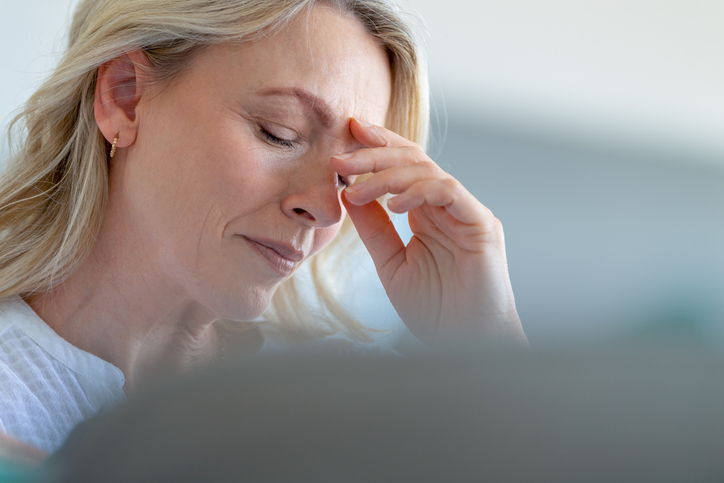 Upset stressed mature woman close up. She looks worried and in pain. She is about to cry