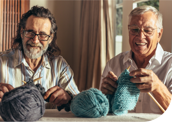 Two elderly men knitting