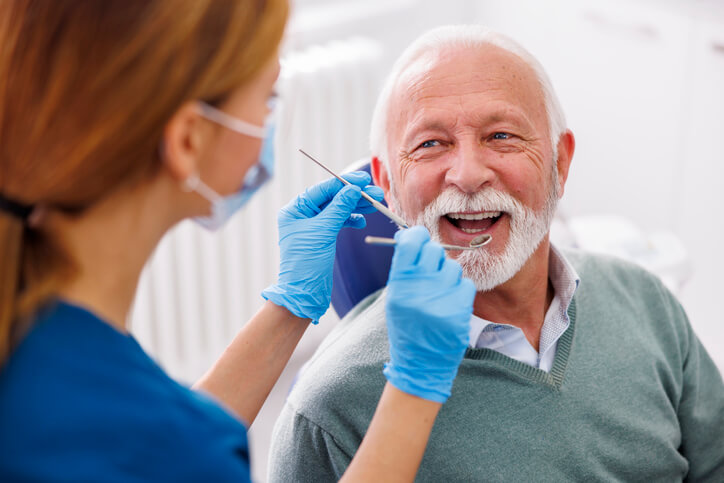 senior getting his teeth checked by dentist