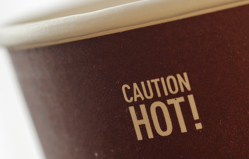 a closeup of the hot warning on a drink cup