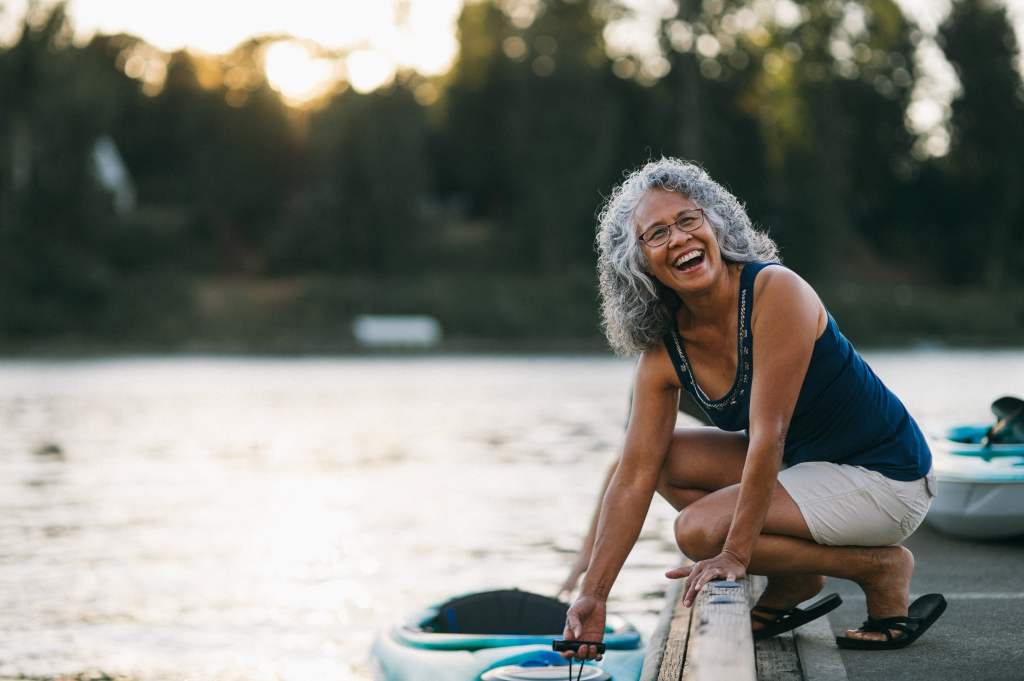 Senior woman laughing by the lake