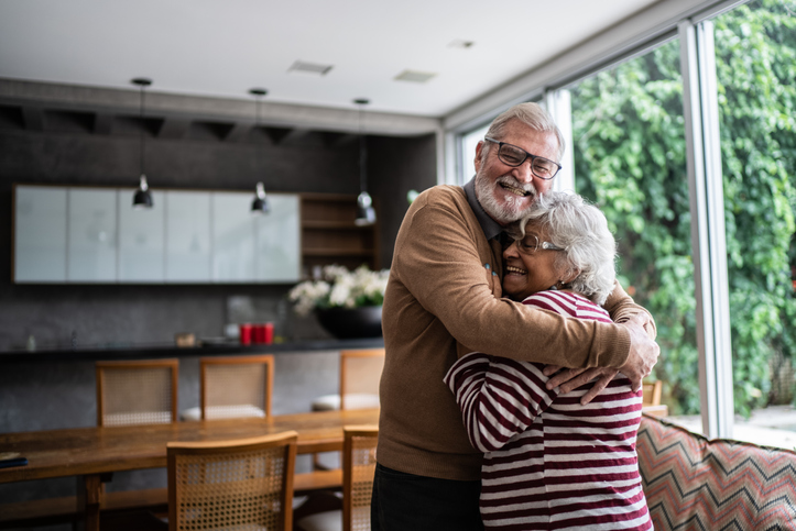 Senior couple hugging each other at home