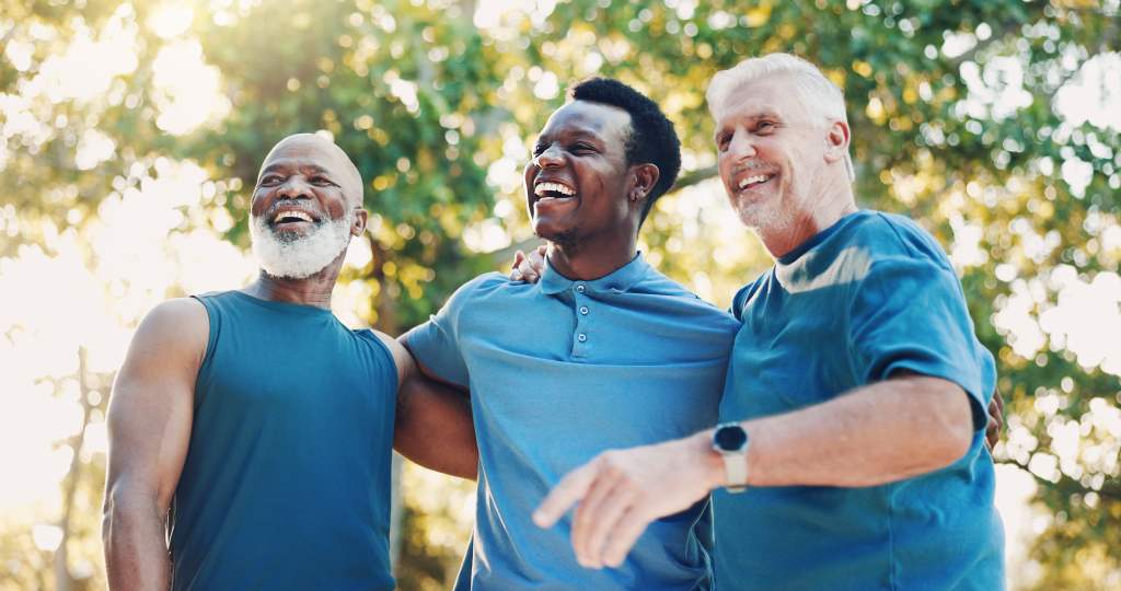 Men laughing for fitness outdoor of mobility training, funny discussion and morning routine. Below, people and coach with embrace of conversation, exercise joke and cardio workout at park