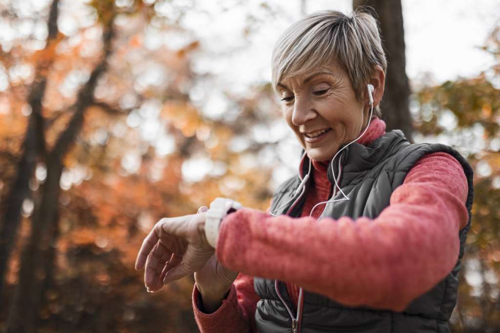 Sporty mature smiling Woman Checking Her Pulse After Exercise