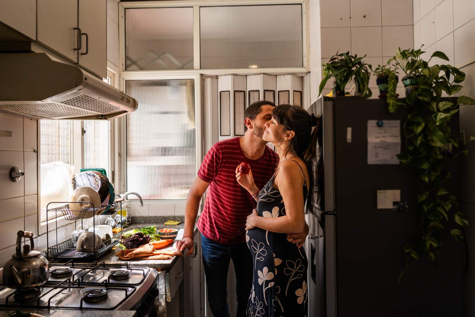 Husband kissing pregnant wife at home
