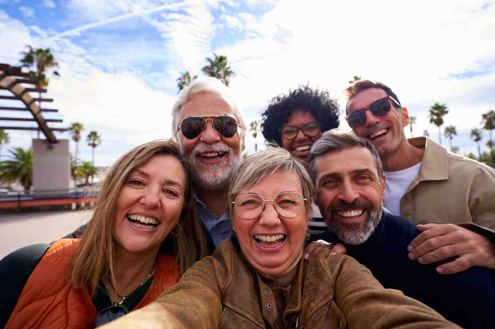 Group of multiracial middle-aged people cheerful and smiling taking a selfie together on their trip outdoor. Mature friends enjoying holidays.