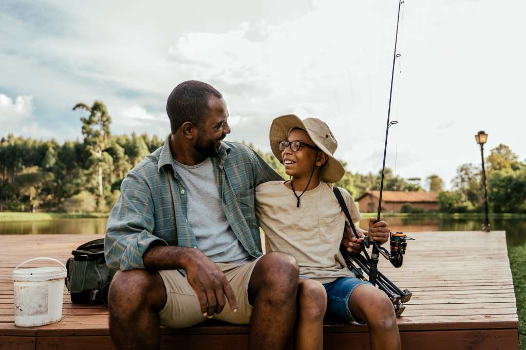 Father and son fishing in the lake relaxing and enjoying nature