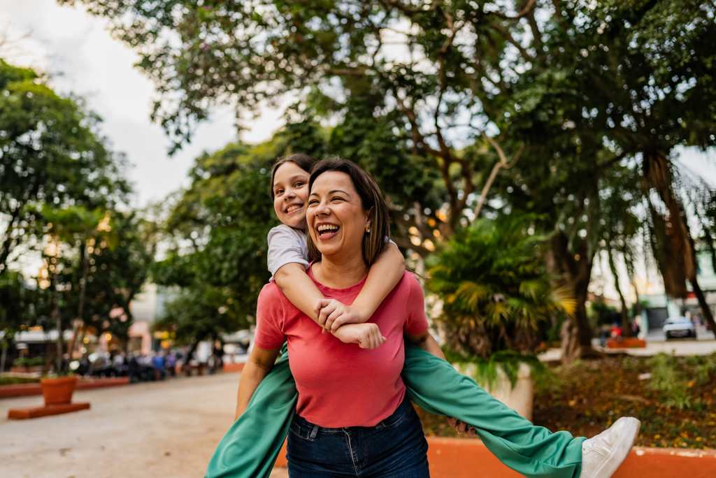 Mother and daughter doing piggyback outdoors