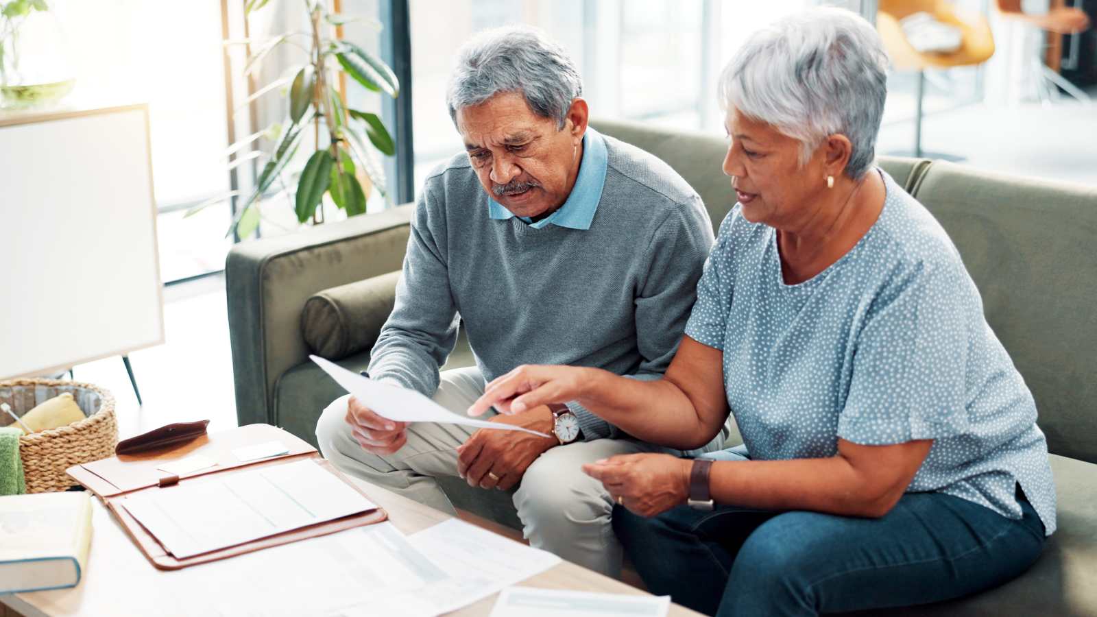 Discussion, finance documents and senior couple in home with debt, mortgage or bills with budget payment. Conversation, paperwork and elderly man with woman for planning retirement account in house.